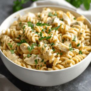 Creamy Chicken Cellentani pasta served in a white bowl with parsley garnish.